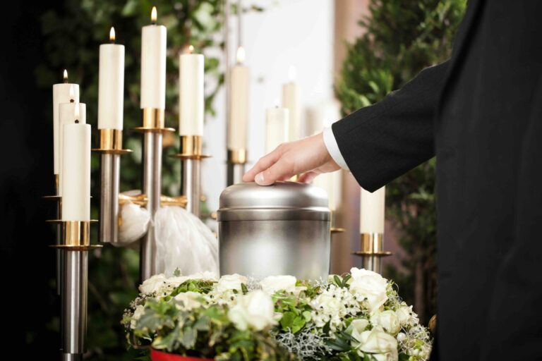 cremazione-costi da valutare per pianificare la spesa particolare di una mano che sfiora urna contenente le ceneri della cremazione durante rito funebre